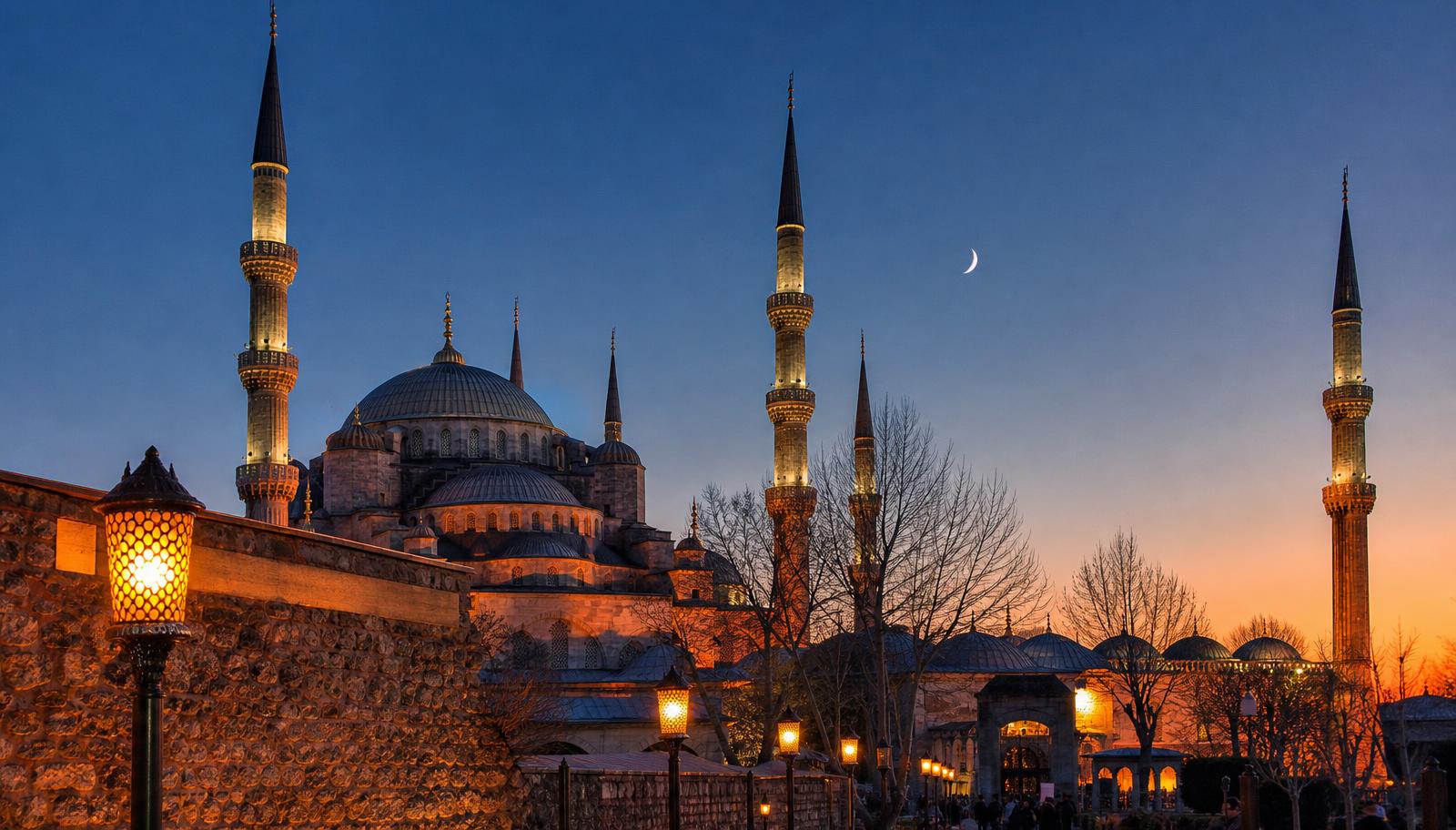 Crescent moon above a mosque at dusk marking the end of Ramadan